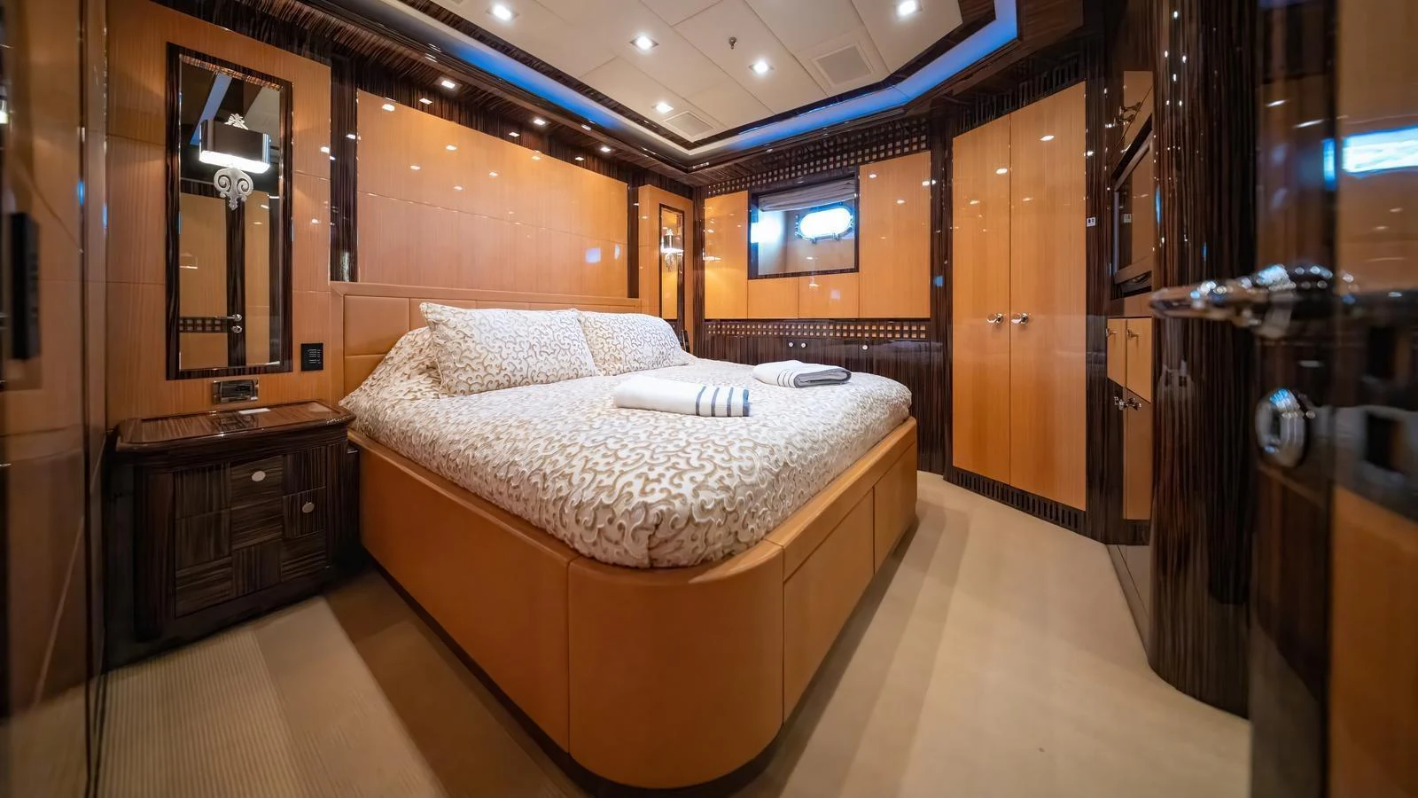 The master stateroom features a spacious bed with luxurious bedding and elegant wood finishes. aboard SEA PEARL Yacht for Sale