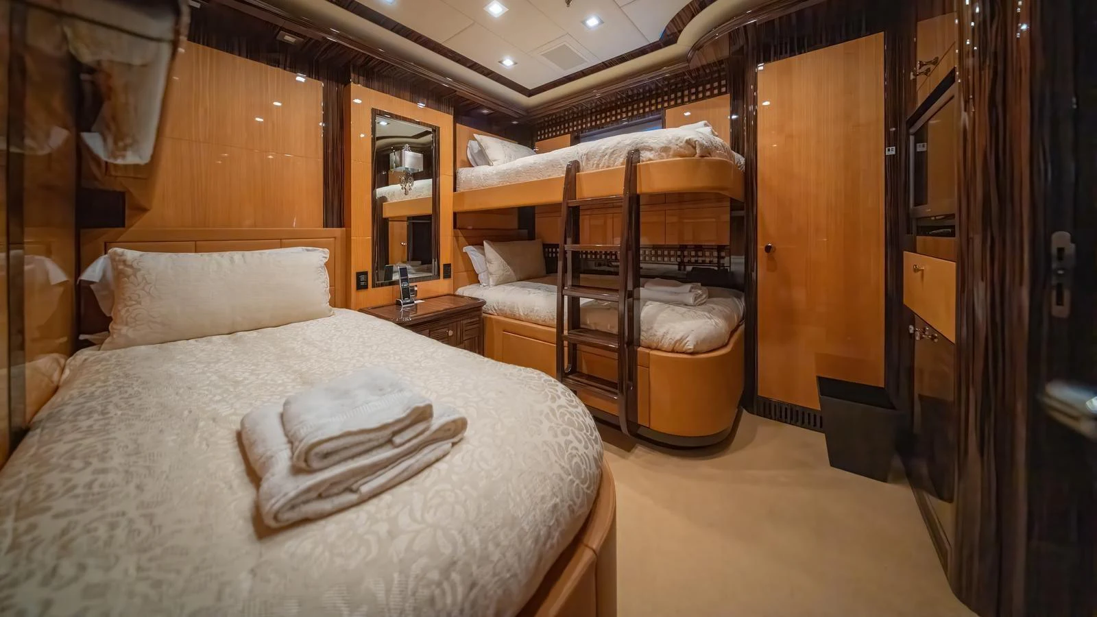 The guest stateroom features cozy bunk beds and a comfortable single bed, creating a warm and inviting atmosphere. aboard SEA PEARL Yacht for Sale