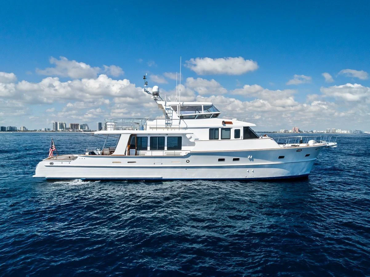 A sleek and elegant yacht cruising on a calm blue sea under a bright sky. aboard EL LEGADO Yacht for Sale