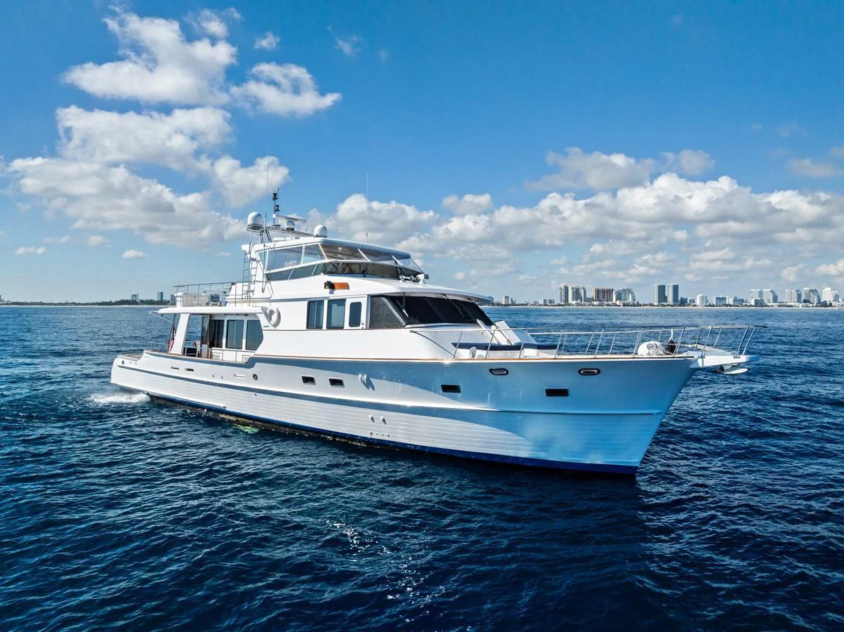 A stunning yacht cruises gracefully on the open water under a clear blue sky. aboard EL LEGADO Yacht for Sale