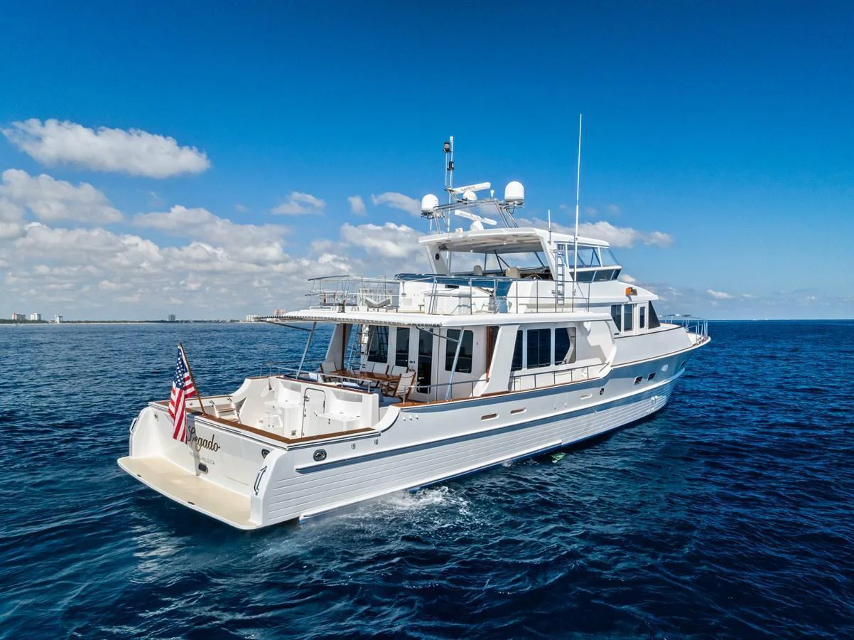 A stunning yacht cruising on the open water under a clear blue sky. aboard EL LEGADO Yacht for Sale