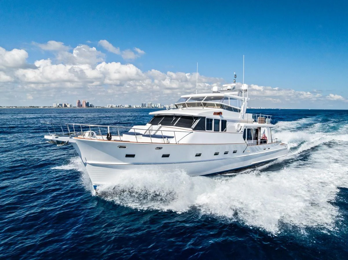 A sleek yacht cruises through the open water under a clear blue sky. aboard EL LEGADO Yacht for Sale