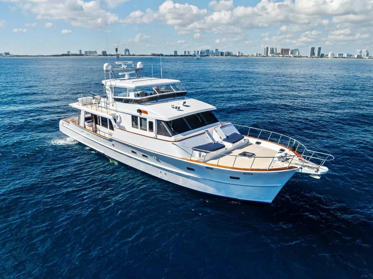 A sleek and elegant yacht cruises through calm blue waters under a bright sky. aboard EL LEGADO Yacht for Sale