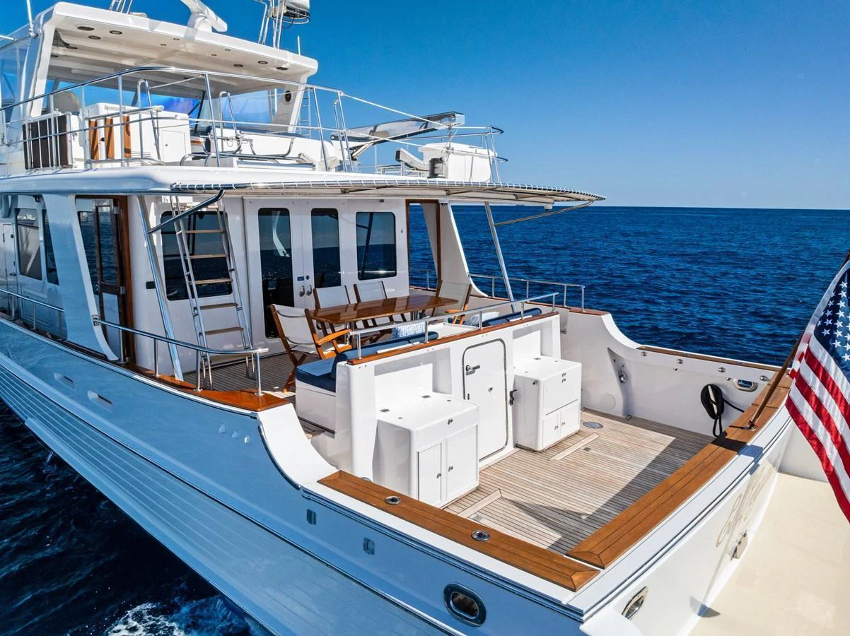 The yacht's aft deck offers a spacious and inviting area for relaxation and entertainment, with a stunning view of the open sea. aboard EL LEGADO Yacht for Sale