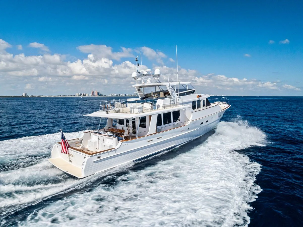 A luxurious yacht cruises through the open sea under a clear blue sky. aboard EL LEGADO Yacht for Sale