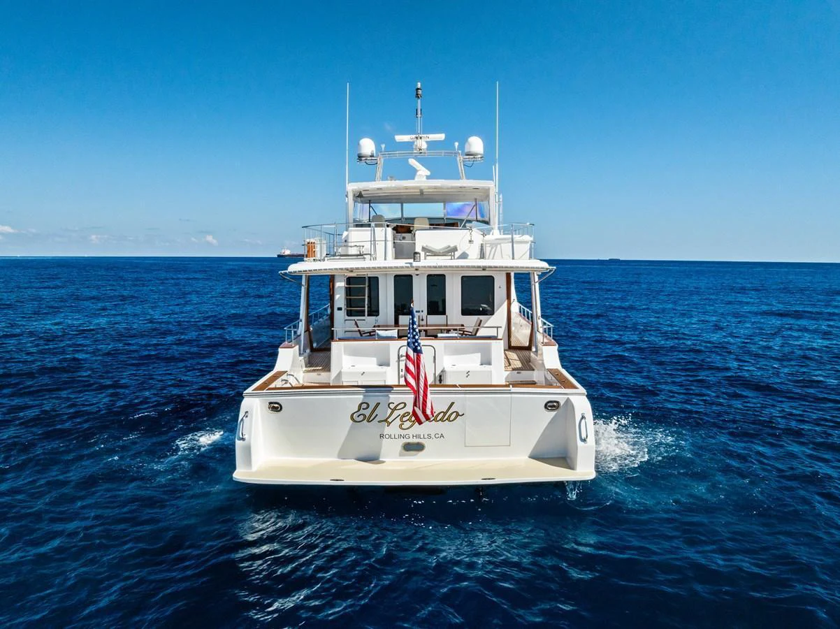 A luxurious yacht cruising on the open sea with a clear blue sky in the background. aboard EL LEGADO Yacht for Sale