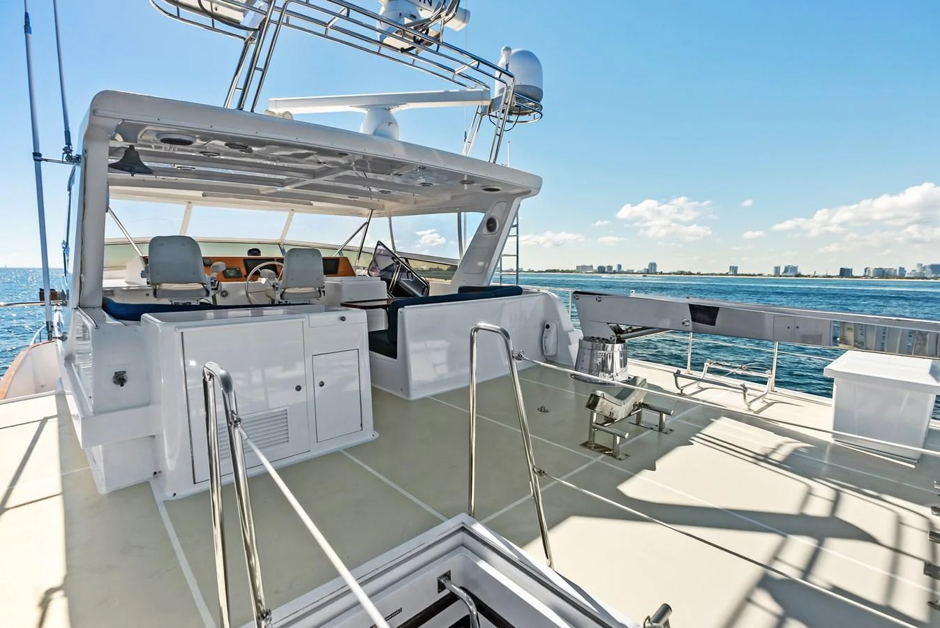 The flybridge offers a spacious and well-equipped area for relaxation and navigation with stunning ocean views. aboard EL LEGADO Yacht for Sale