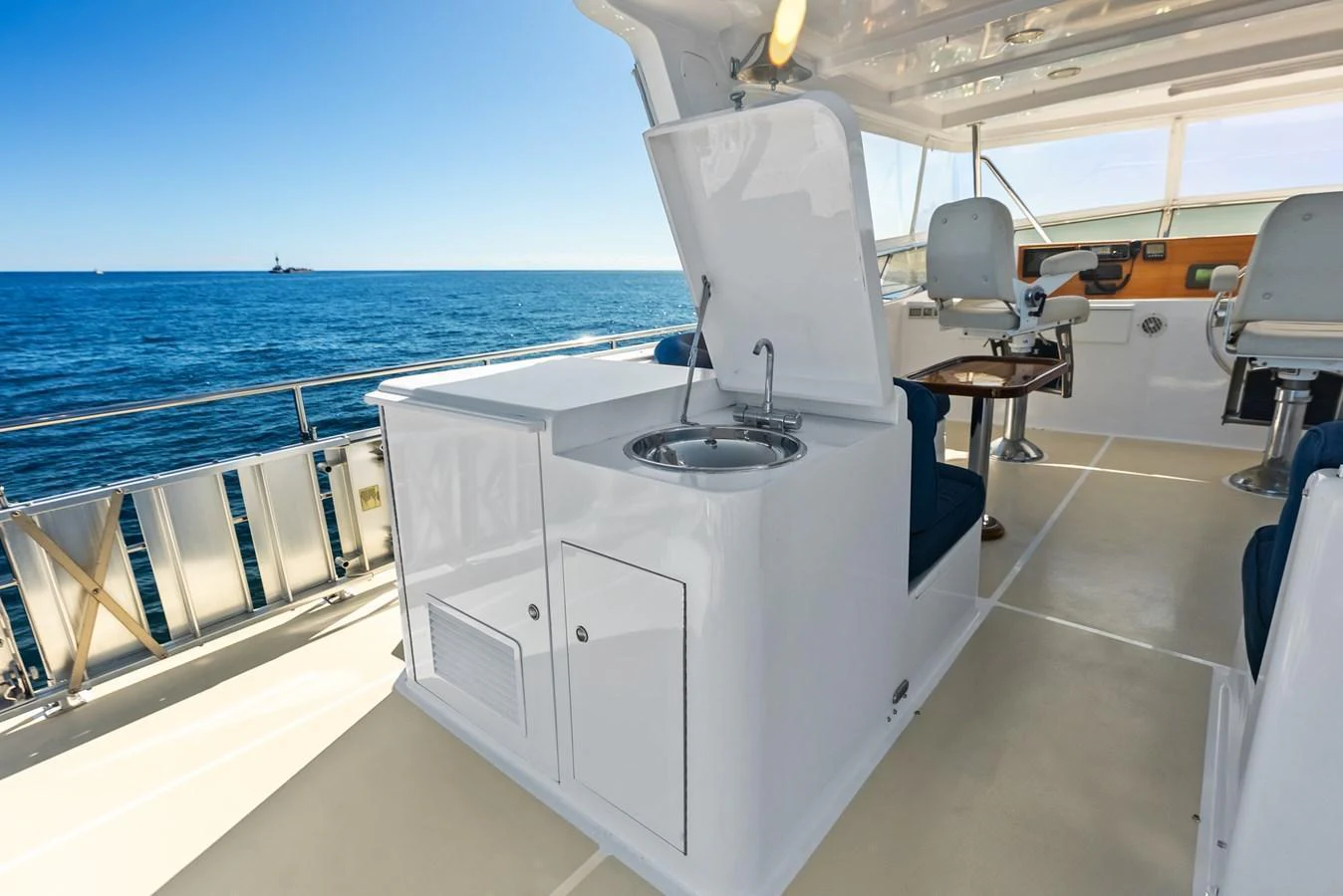 The flybridge offers a spacious and functional area with a sink and seating, perfect for enjoying the open sea. aboard EL LEGADO Yacht for Sale