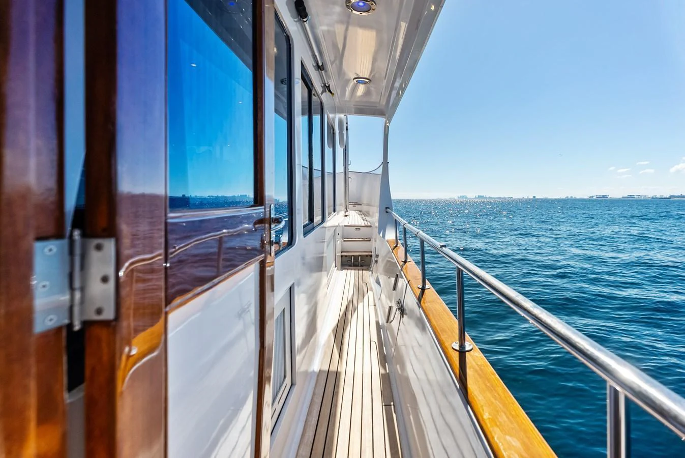 The yacht's side deck offers a sleek passageway with stunning ocean views. aboard EL LEGADO Yacht for Sale