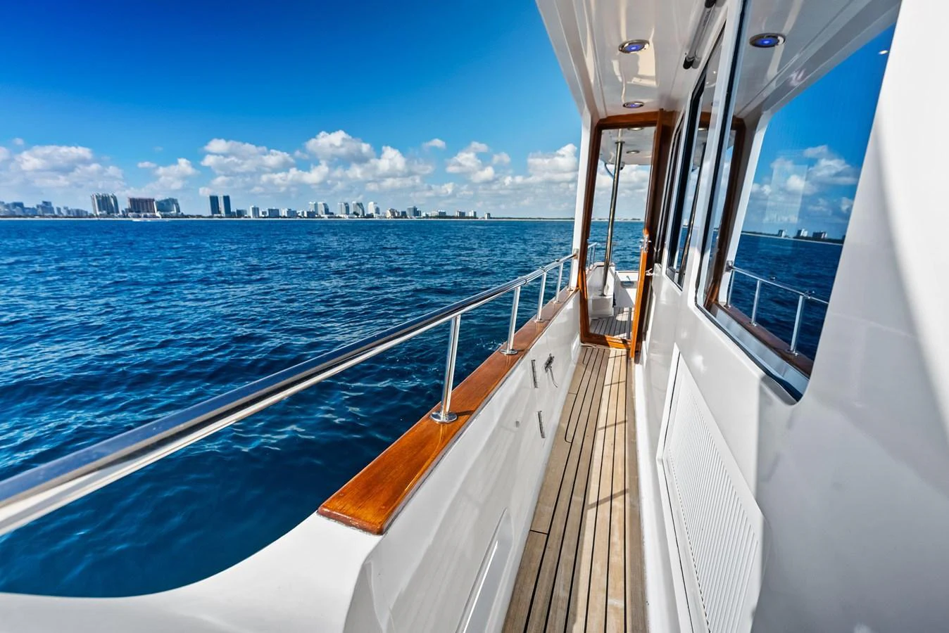 The side deck offers a stunning view of the open sea and city skyline. aboard EL LEGADO Yacht for Sale
