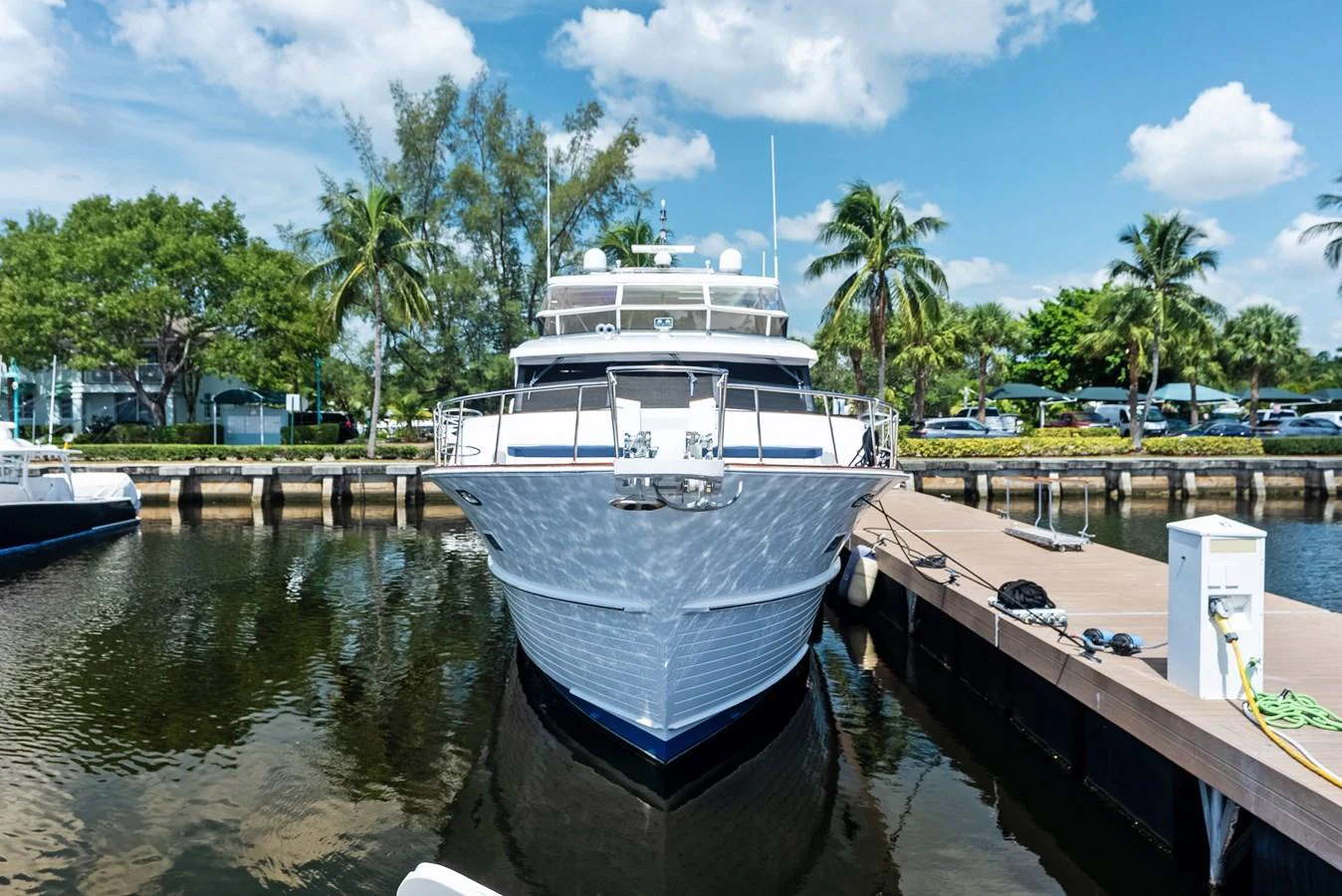 A luxurious yacht is docked at a serene marina, showcasing its elegant bow and sleek design. aboard EL LEGADO Yacht for Sale