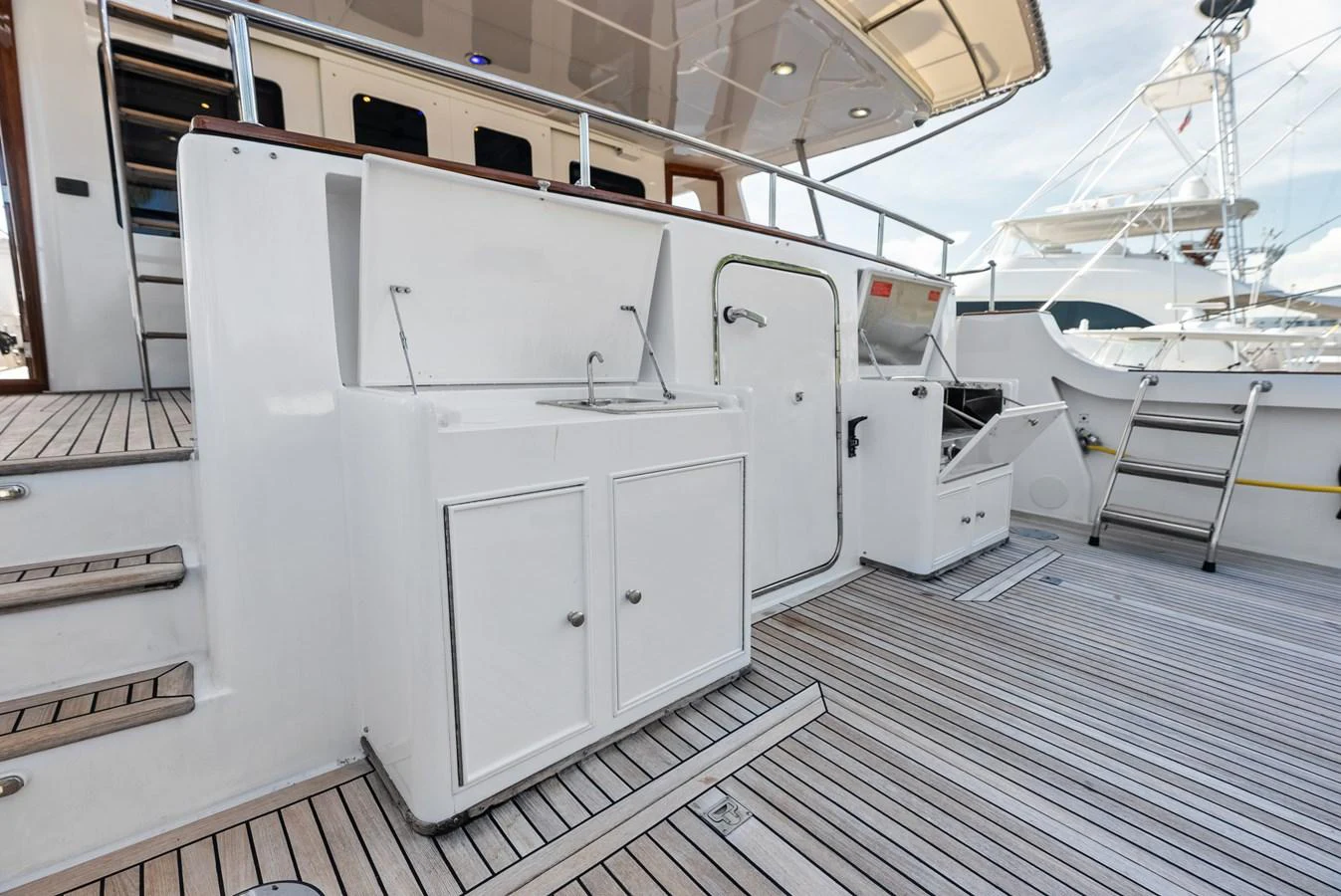 The aft deck features a well-equipped outdoor galley with a sink and storage cabinets. aboard EL LEGADO Yacht for Sale