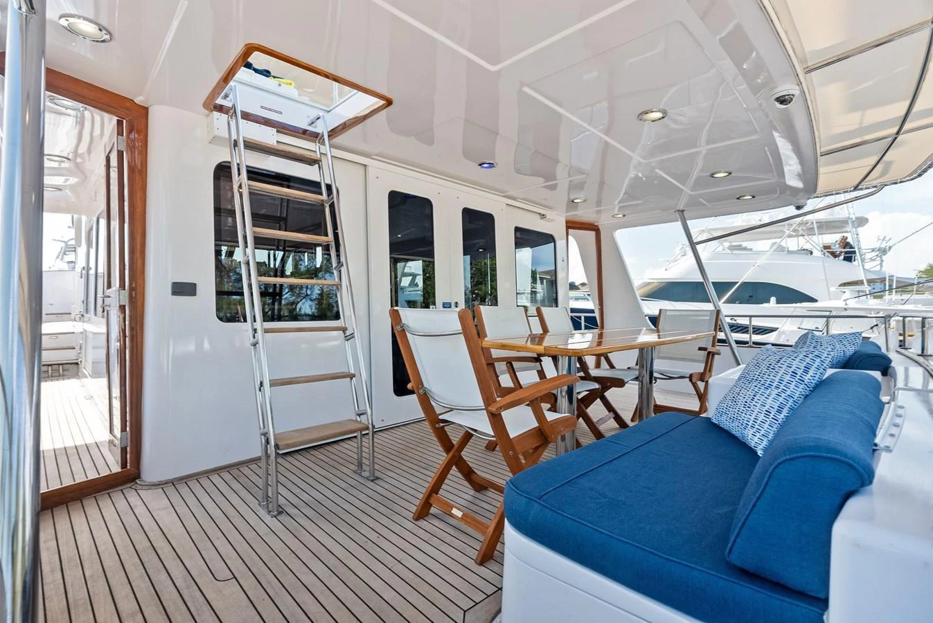 The aft deck features comfortable seating and a dining area with a view of the marina. aboard EL LEGADO Yacht for Sale