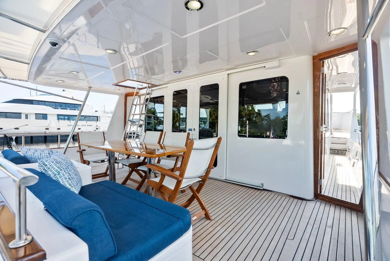 The aft deck features comfortable seating and a dining area, perfect for outdoor relaxation and meals. aboard EL LEGADO Yacht for Sale