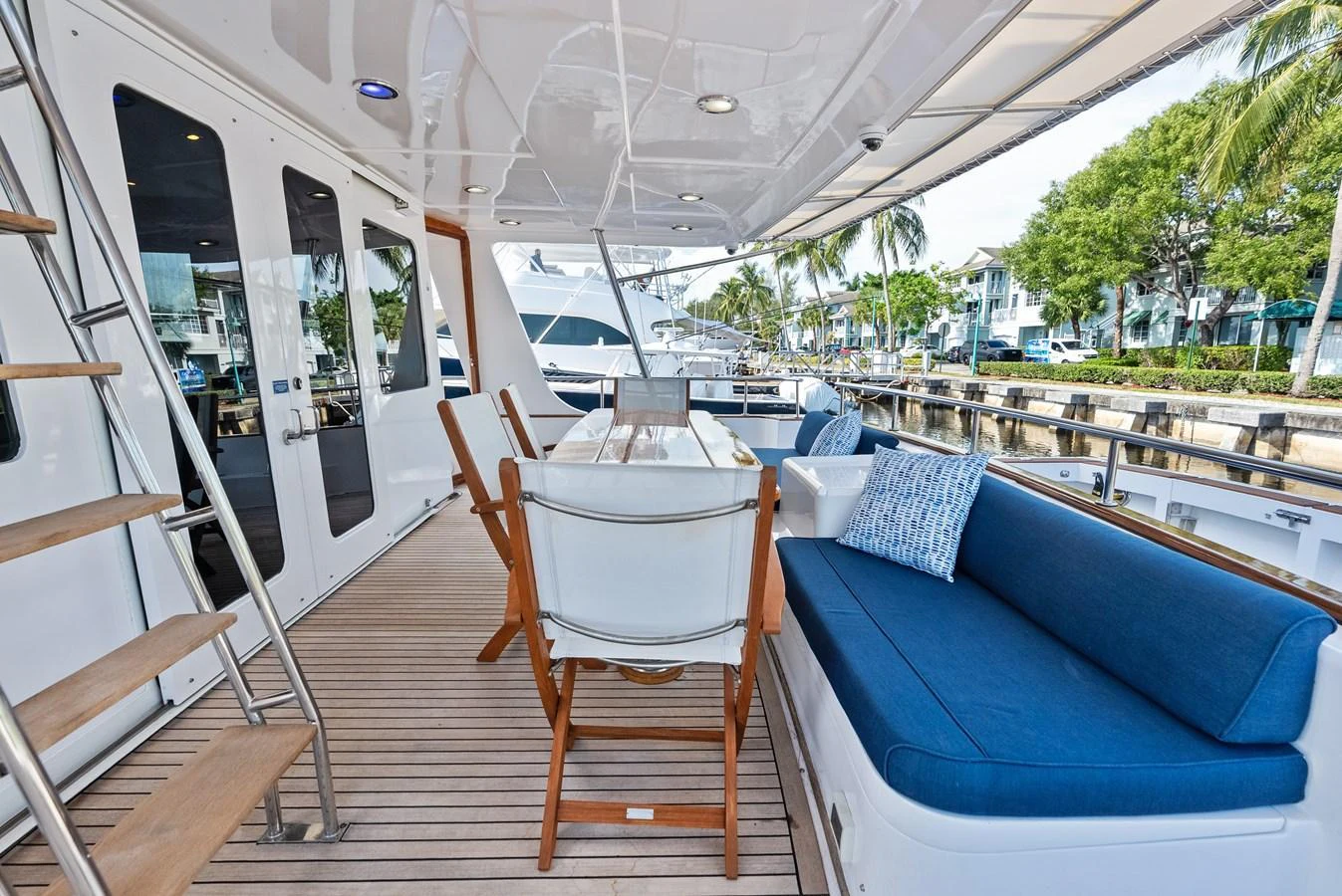 The aft deck features a comfortable seating area with a dining table, perfect for alfresco meals and relaxation. aboard EL LEGADO Yacht for Sale