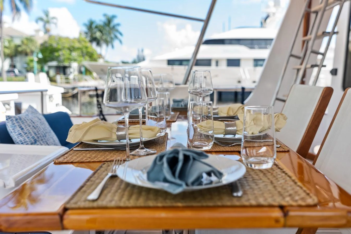 An elegant outdoor dining area set for a meal, offering a luxurious waterfront view. aboard EL LEGADO Yacht for Sale
