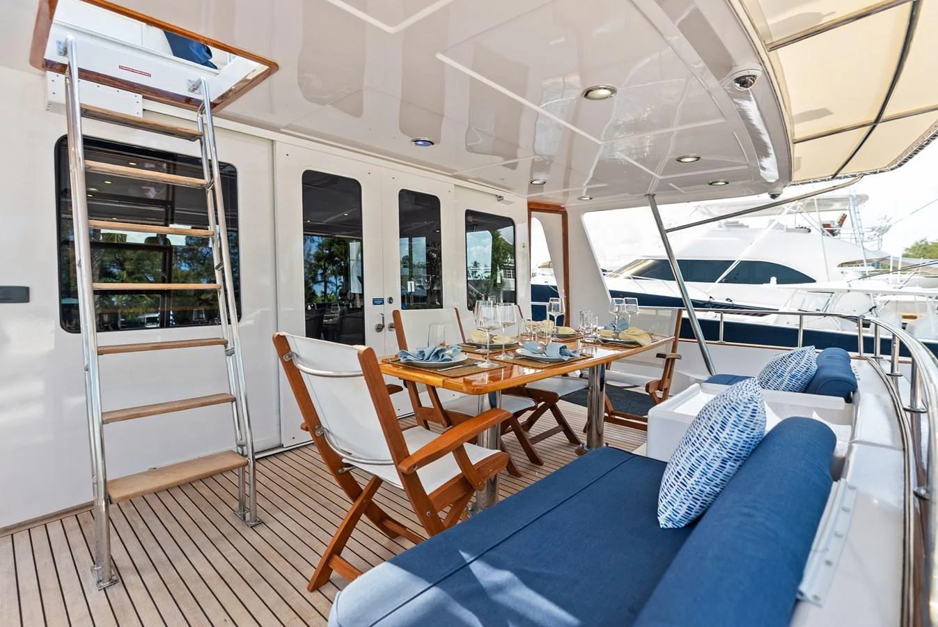 The aft deck features a stylish dining area with comfortable seating and elegant table settings. aboard EL LEGADO Yacht for Sale
