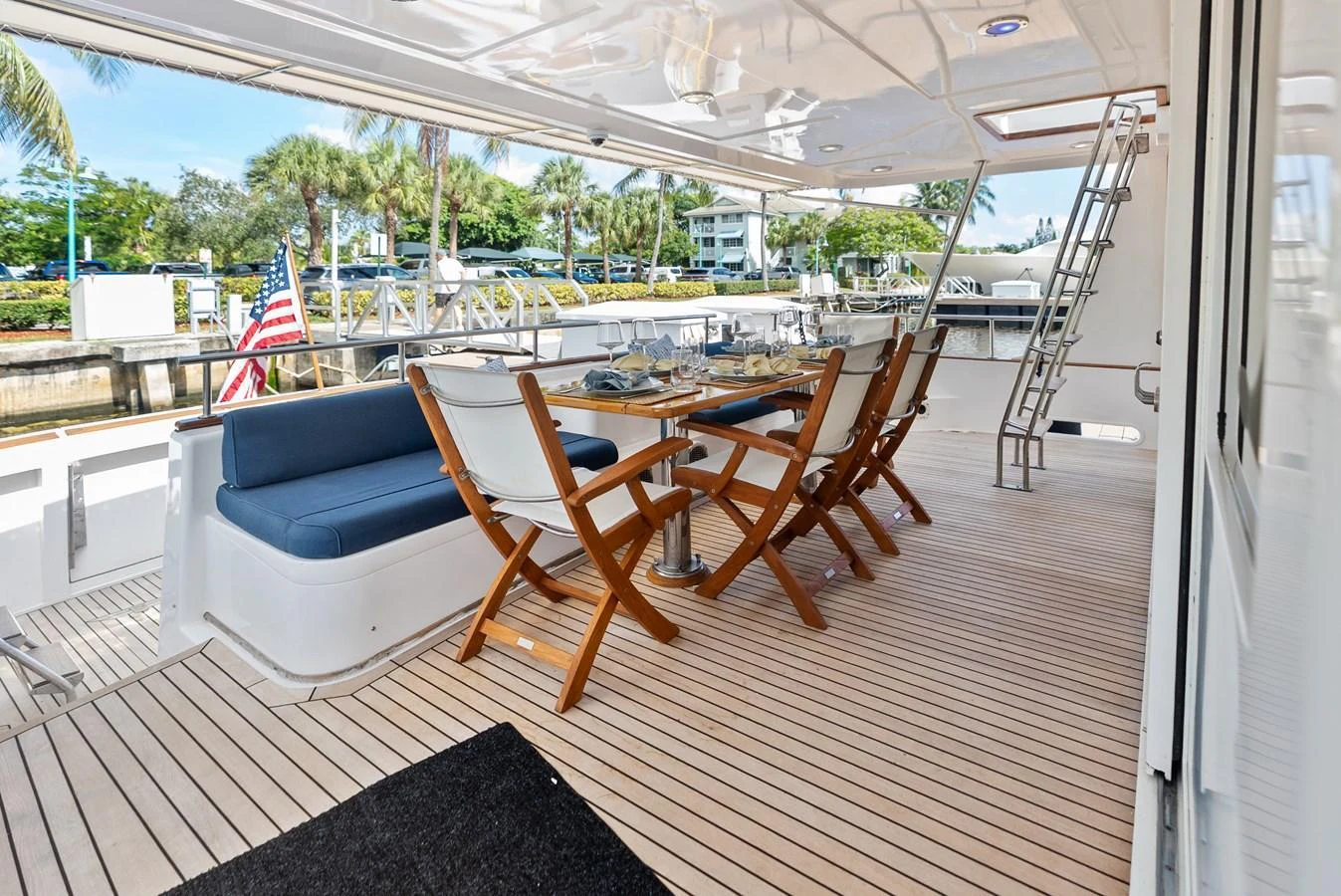 The aft deck features a stylish dining area with comfortable seating and a beautiful view. aboard EL LEGADO Yacht for Sale