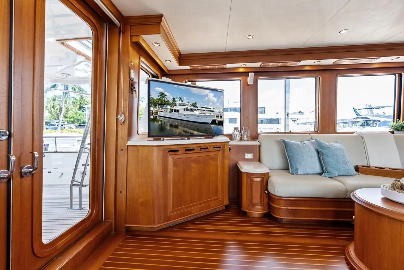 The salon features elegant wood paneling, a comfortable seating area, and a large TV for entertainment. aboard EL LEGADO Yacht for Sale