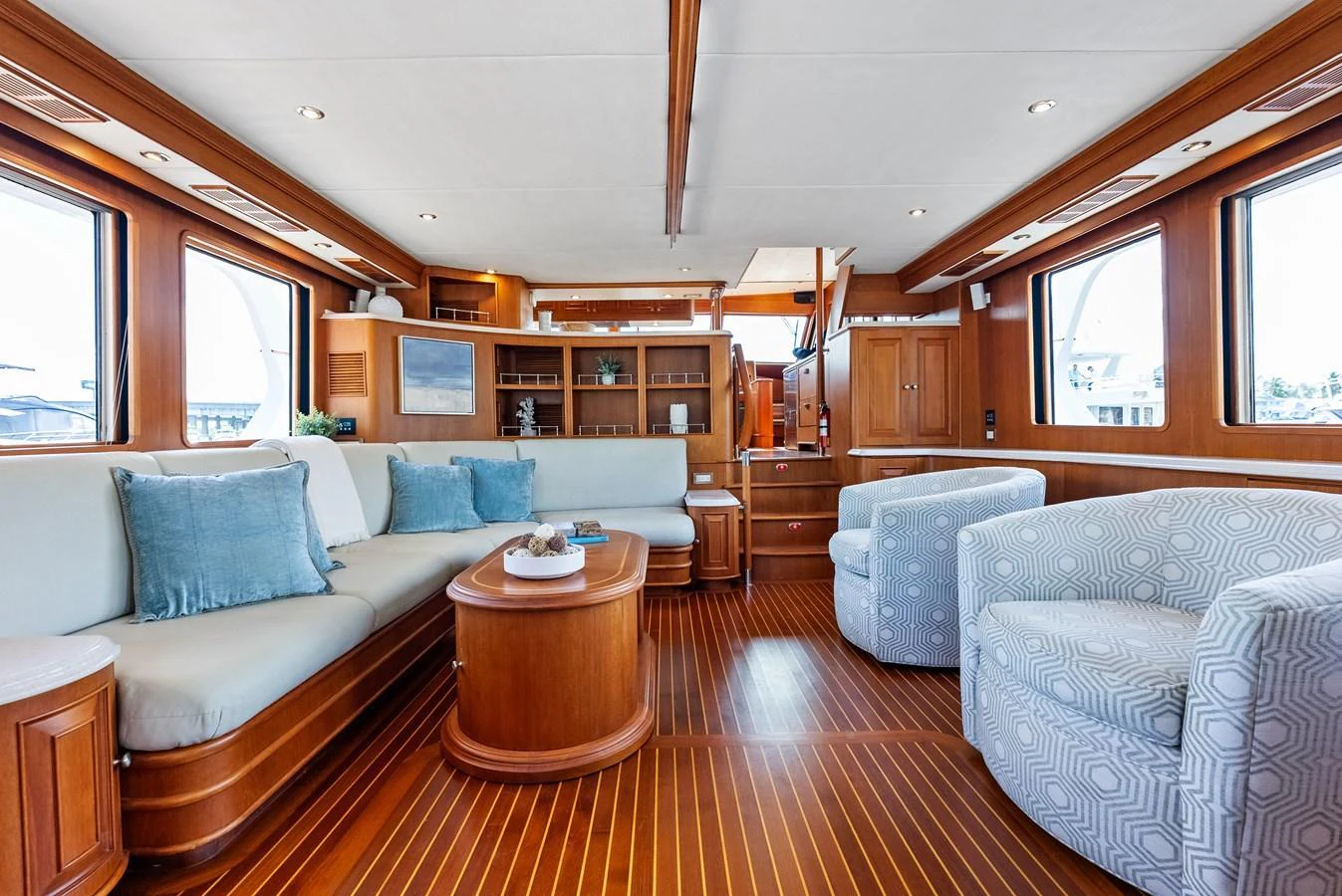 The yacht's salon features elegant wood finishes, plush seating, and ample natural light. aboard EL LEGADO Yacht for Sale