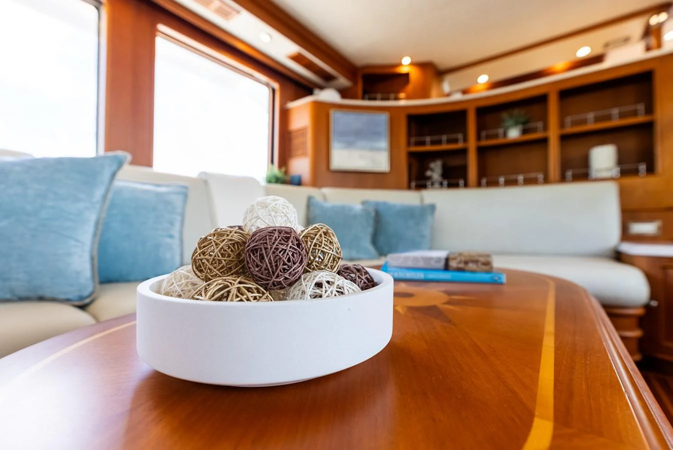 The yacht's salon features a cozy seating area with a decorative centerpiece on a wooden table. aboard EL LEGADO Yacht for Sale