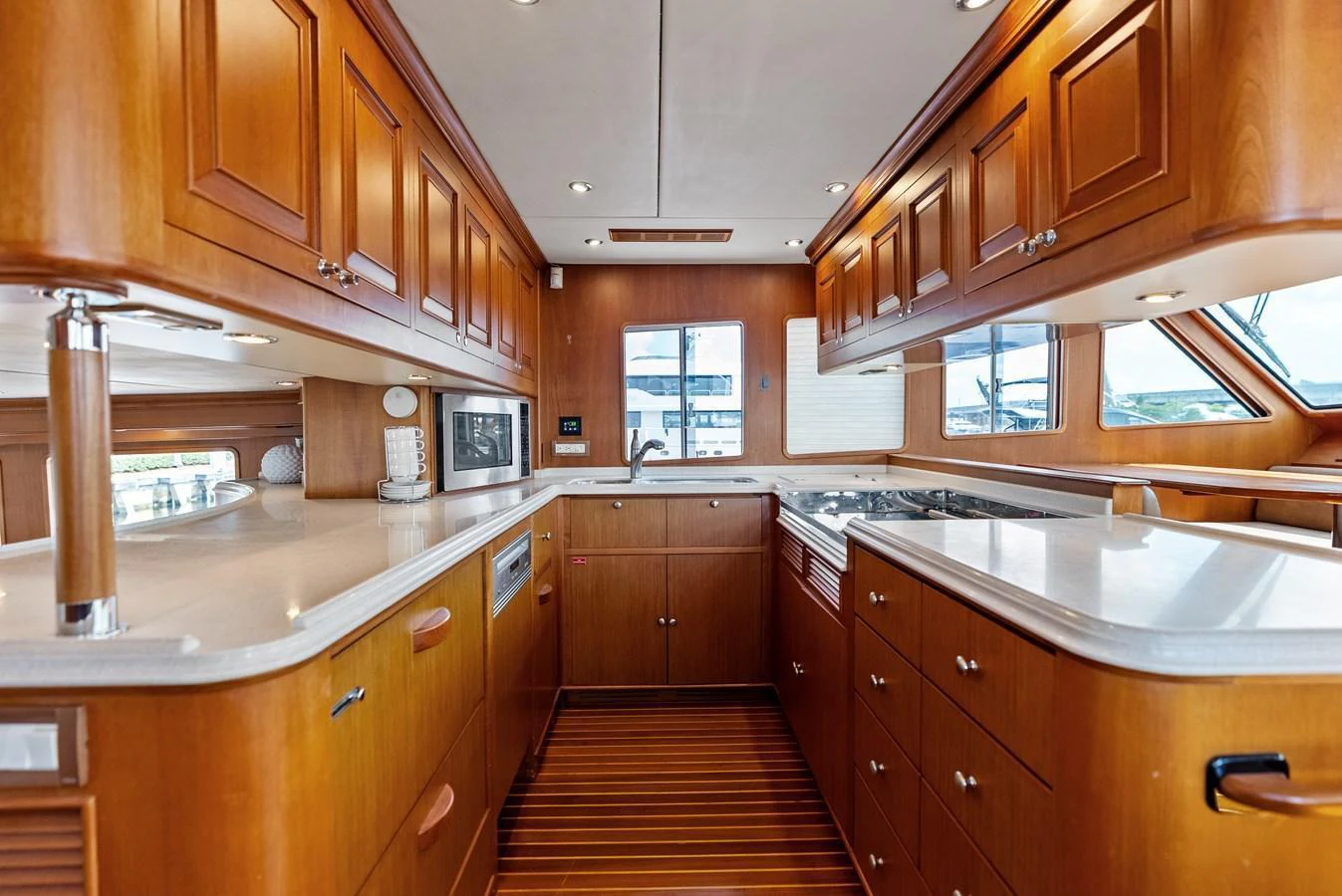 The yacht's galley features warm wood cabinetry and modern appliances, creating a functional and inviting space. aboard EL LEGADO Yacht for Sale