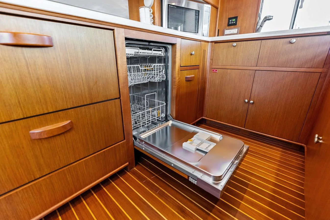 The galley features a built-in dishwasher and ample wooden cabinetry for storage. aboard EL LEGADO Yacht for Sale