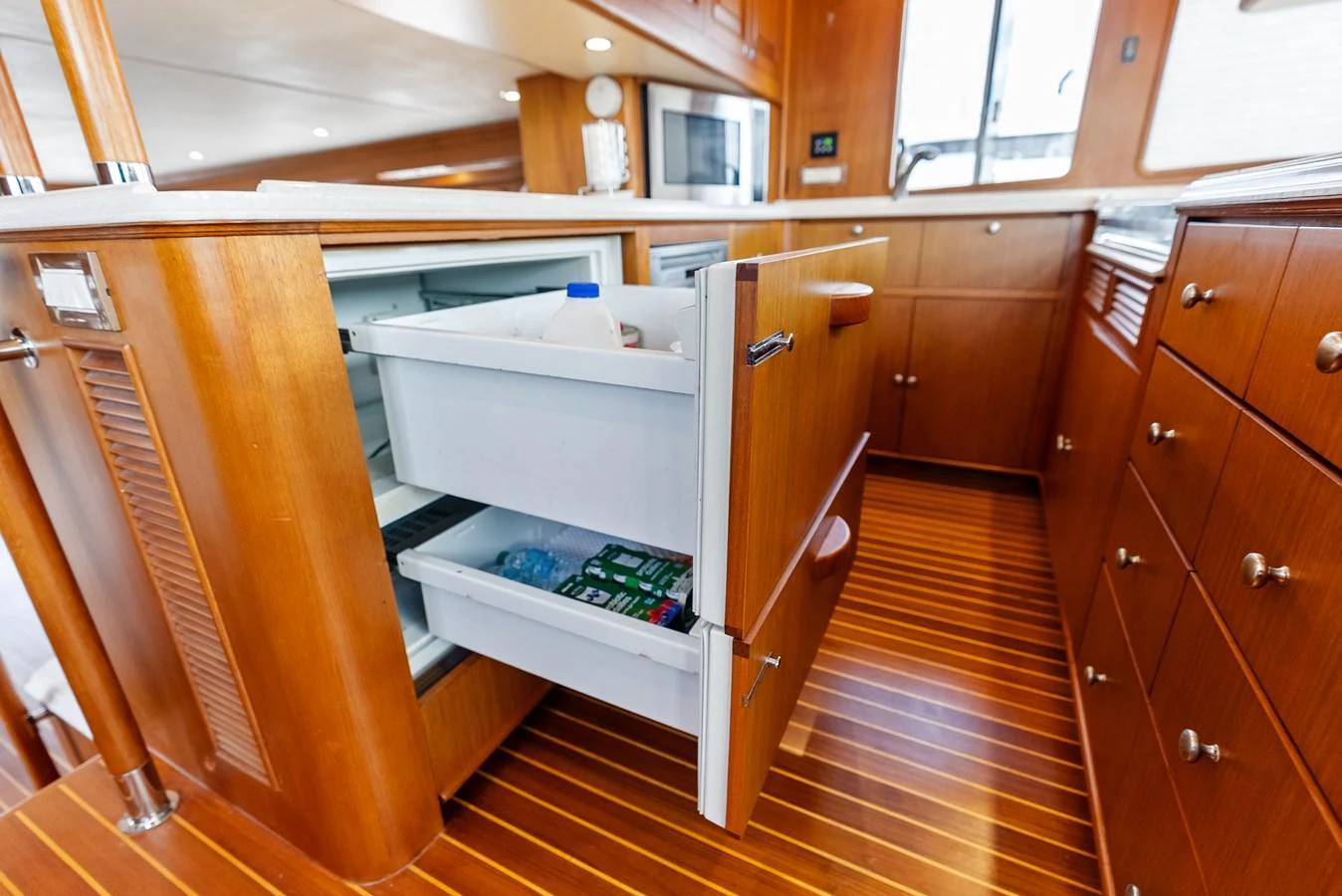 The galley features wooden cabinetry and modern appliances, including a pull-out refrigerator. aboard EL LEGADO Yacht for Sale