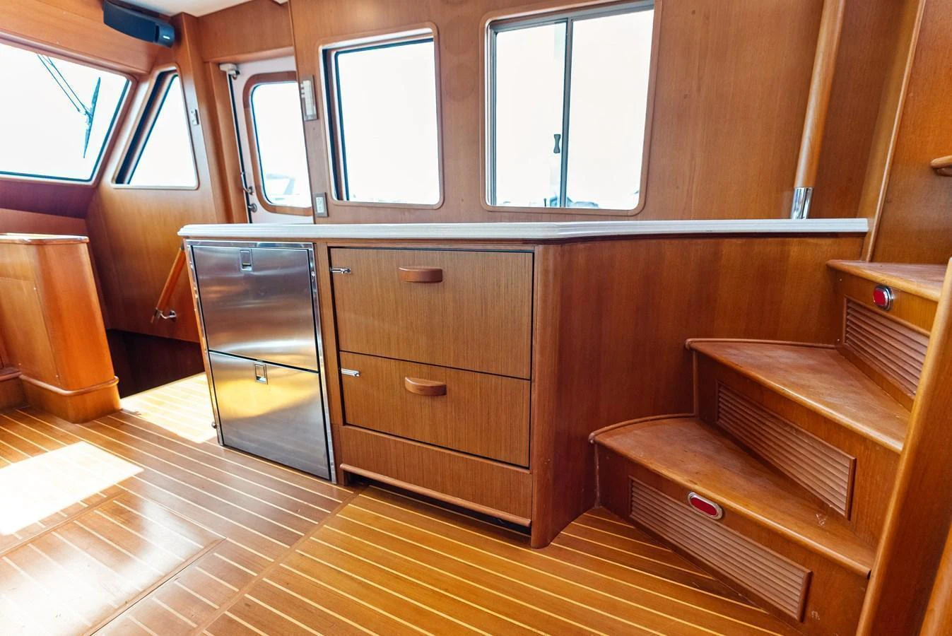 The yacht's interior features warm wooden cabinetry and flooring, creating a cozy and inviting atmosphere. aboard EL LEGADO Yacht for Sale