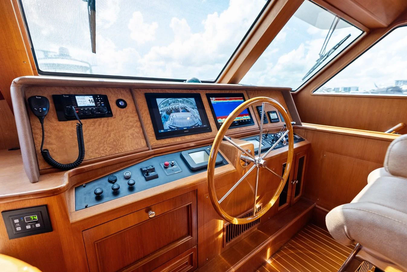 The helm station features advanced navigation equipment and a classic wooden steering wheel. aboard EL LEGADO Yacht for Sale
