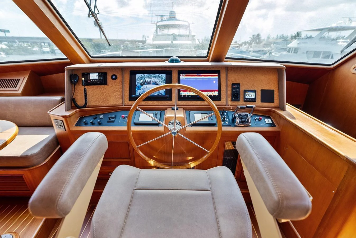 The helm station features a luxurious wooden dashboard with modern navigation equipment and comfortable seating. aboard EL LEGADO Yacht for Sale