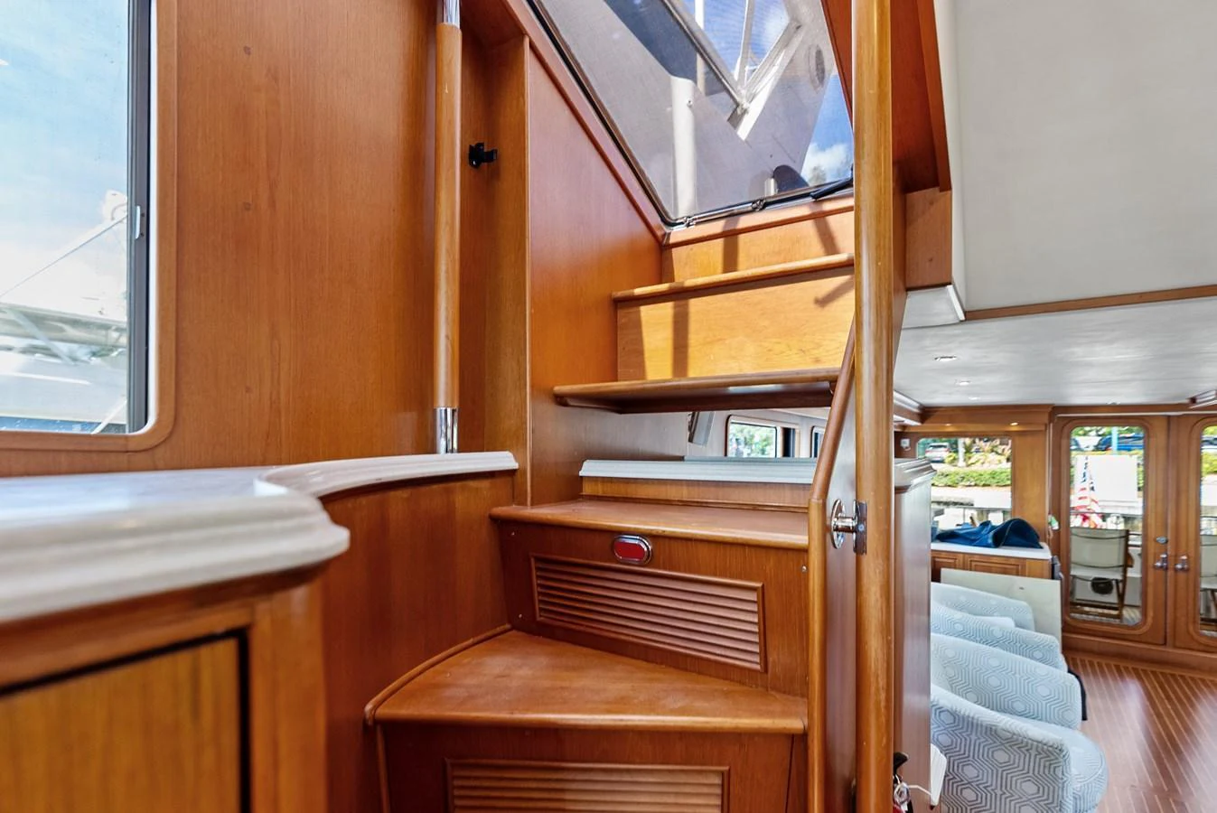 A beautifully crafted wooden staircase leads to the upper deck, showcasing the yacht's elegant interior design. aboard EL LEGADO Yacht for Sale