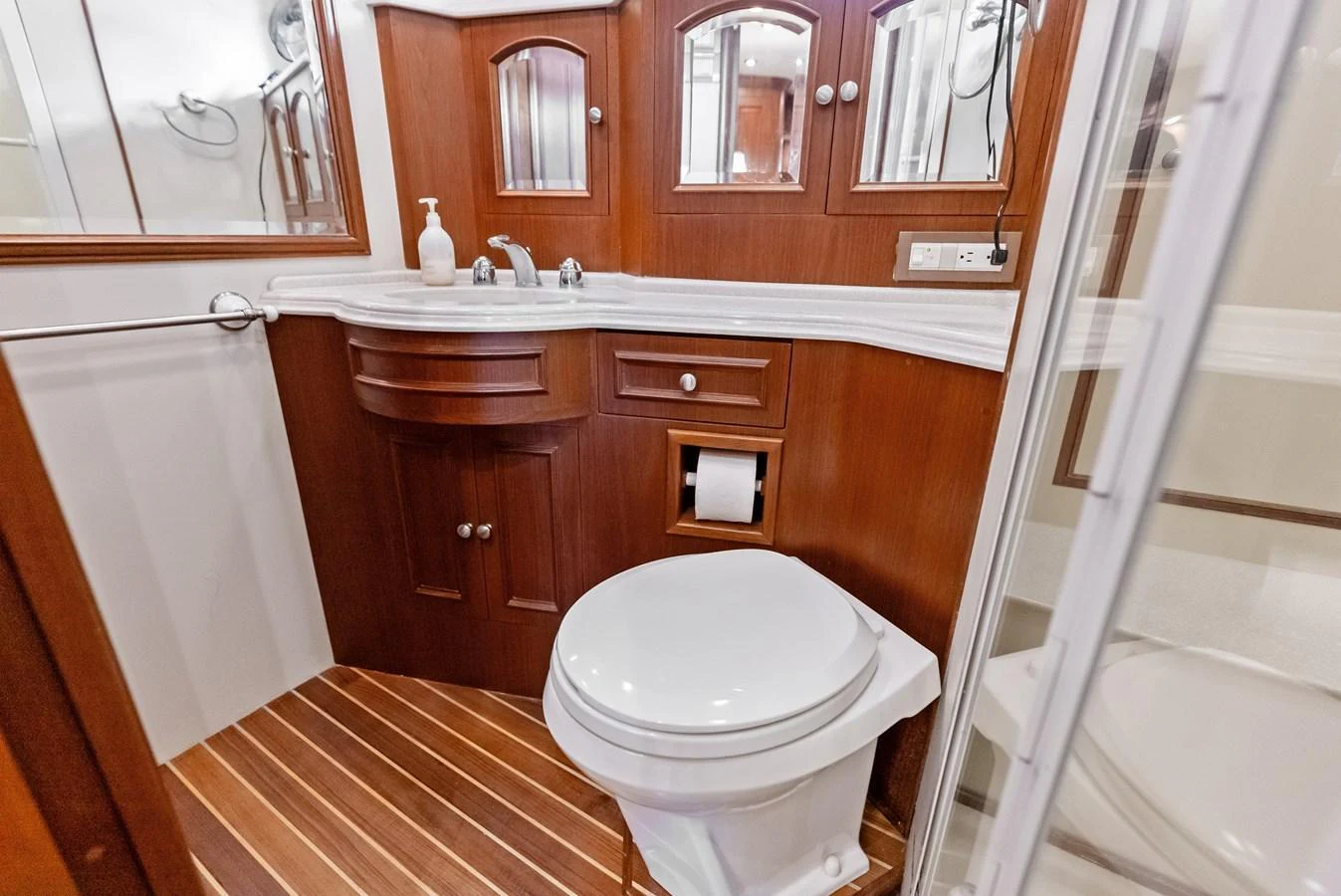 The yacht's head features elegant wood cabinetry and modern fixtures. aboard EL LEGADO Yacht for Sale