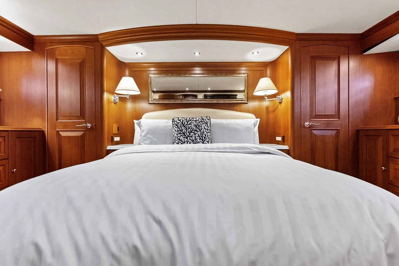 The master stateroom features a luxurious bed with elegant wooden cabinetry and ambient lighting. aboard EL LEGADO Yacht for Sale