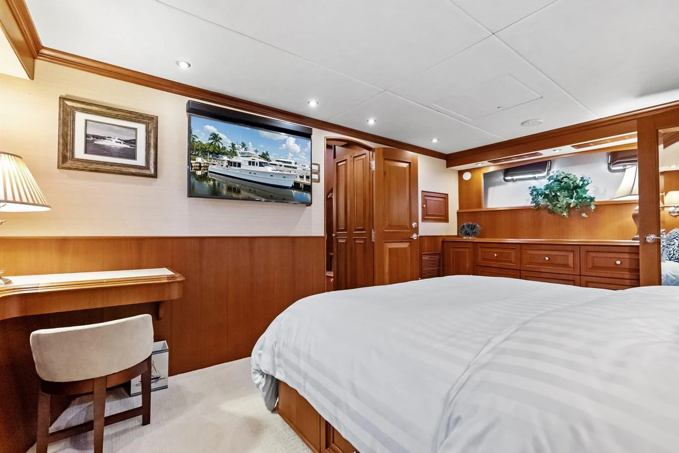The stateroom features a comfortable bed, wooden cabinetry, and tasteful decor. aboard EL LEGADO Yacht for Sale