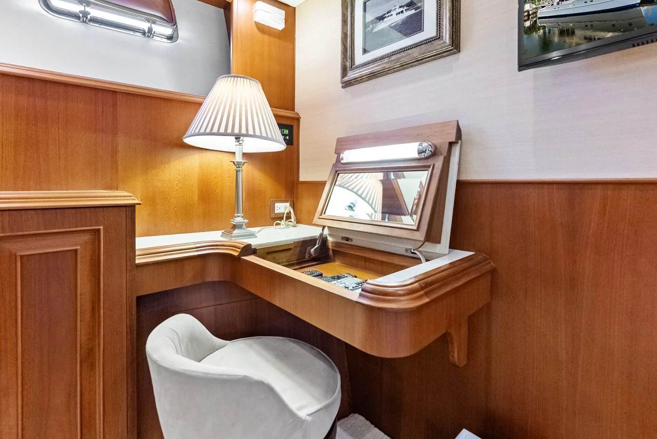 The yacht's interior features a cozy vanity area with a mirror, lamp, and comfortable seating. aboard EL LEGADO Yacht for Sale