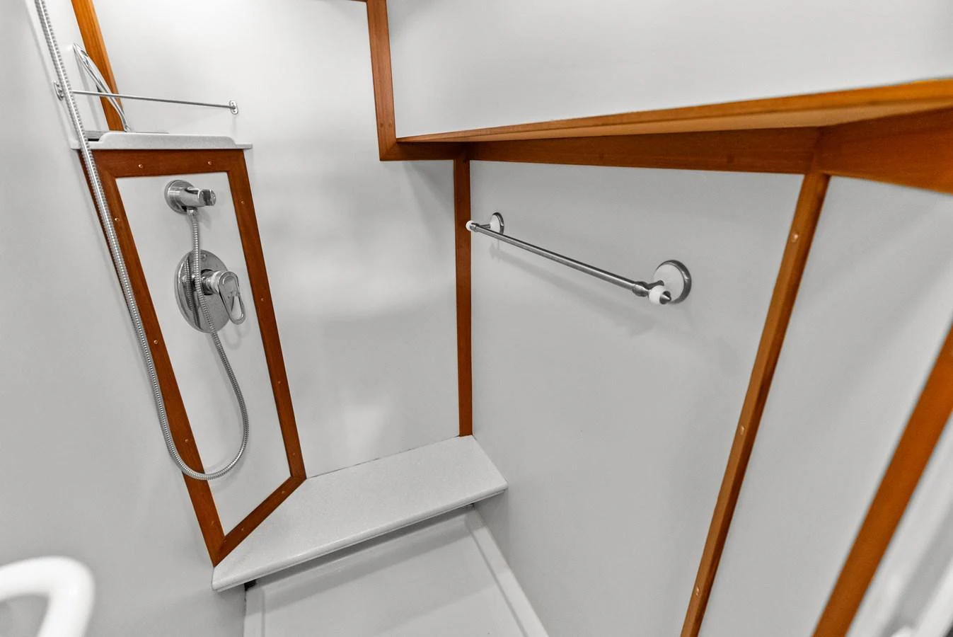 The yacht features a sleek and modern shower area with wooden accents. aboard EL LEGADO Yacht for Sale