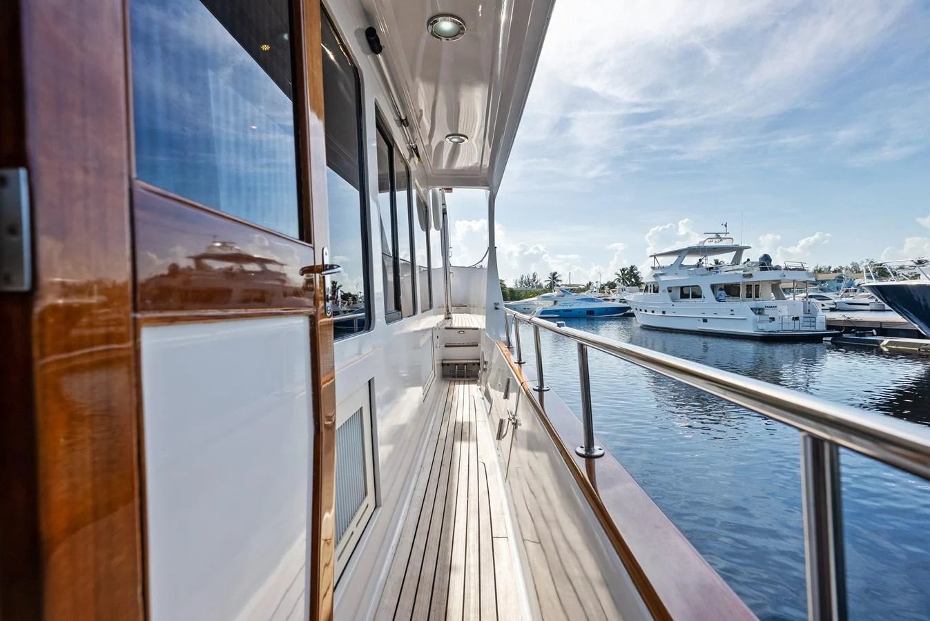 The side deck offers a serene walkway with polished wood and stainless steel railings, perfect for a leisurely stroll while enjoying the view. aboard EL LEGADO Yacht for Sale