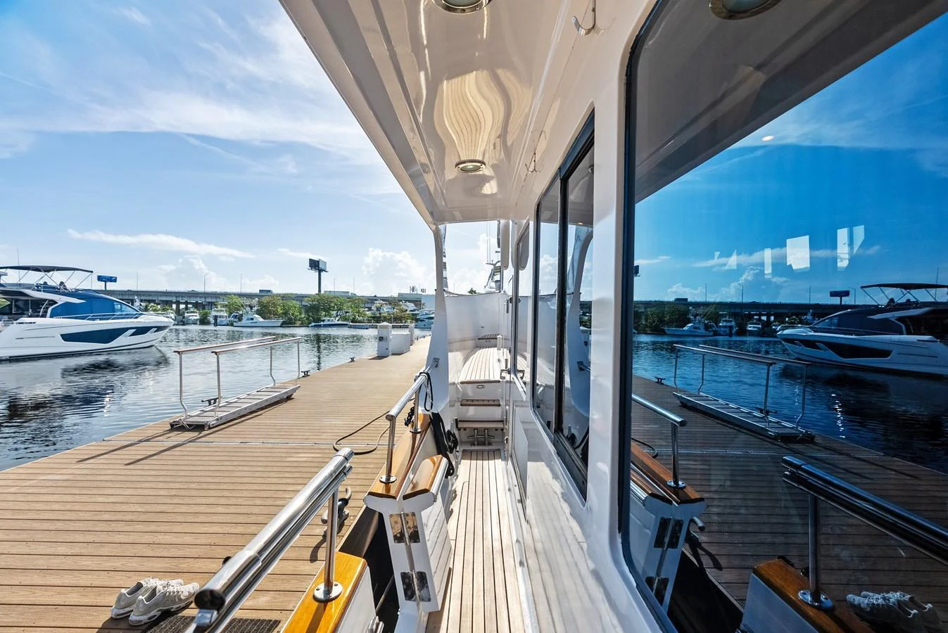 The side deck of the yacht offers a sleek walkway with a view of the marina. aboard EL LEGADO Yacht for Sale