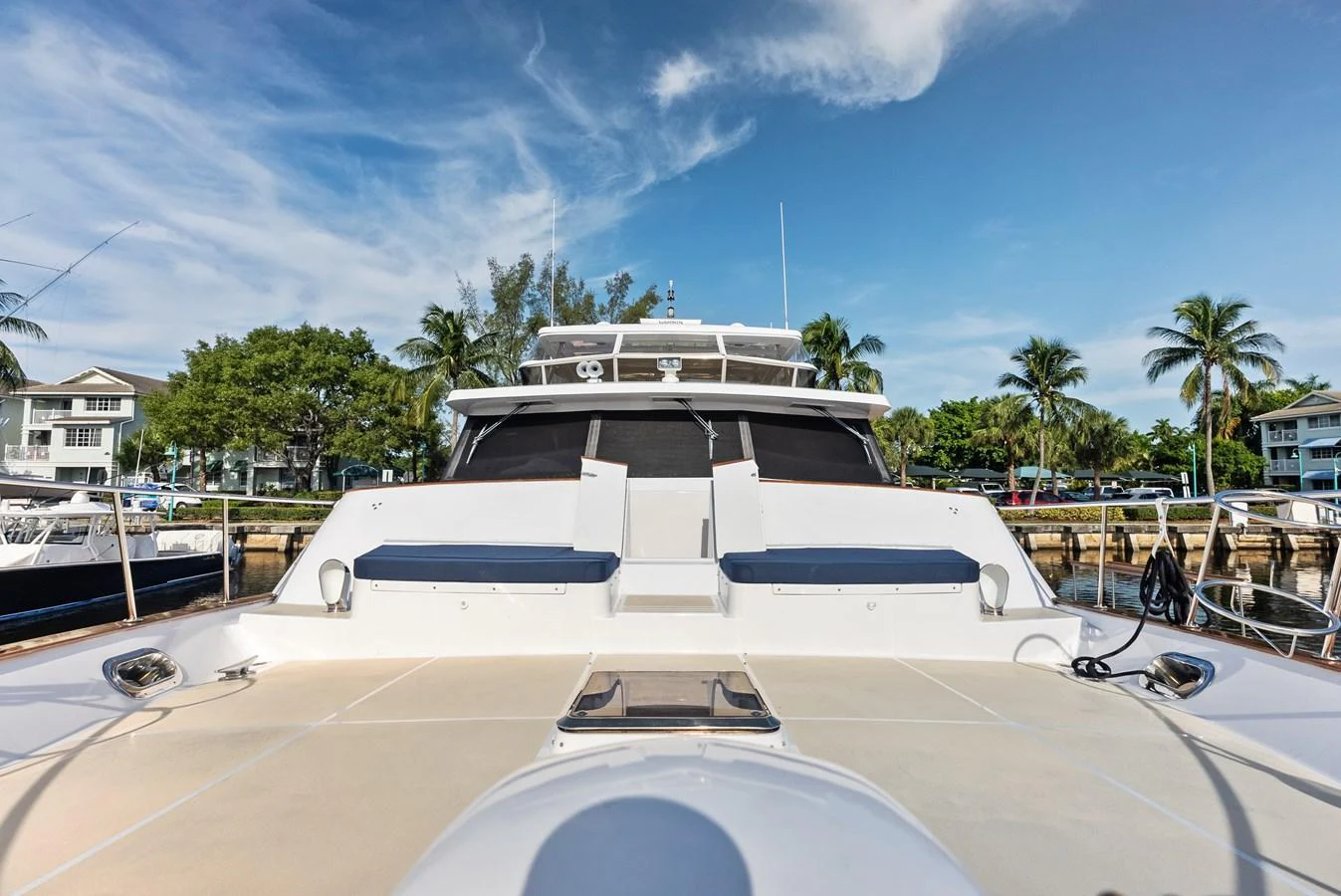 The yacht's bow area is showcased with a clear view of the deck and lounging space under a bright sky. aboard EL LEGADO Yacht for Sale