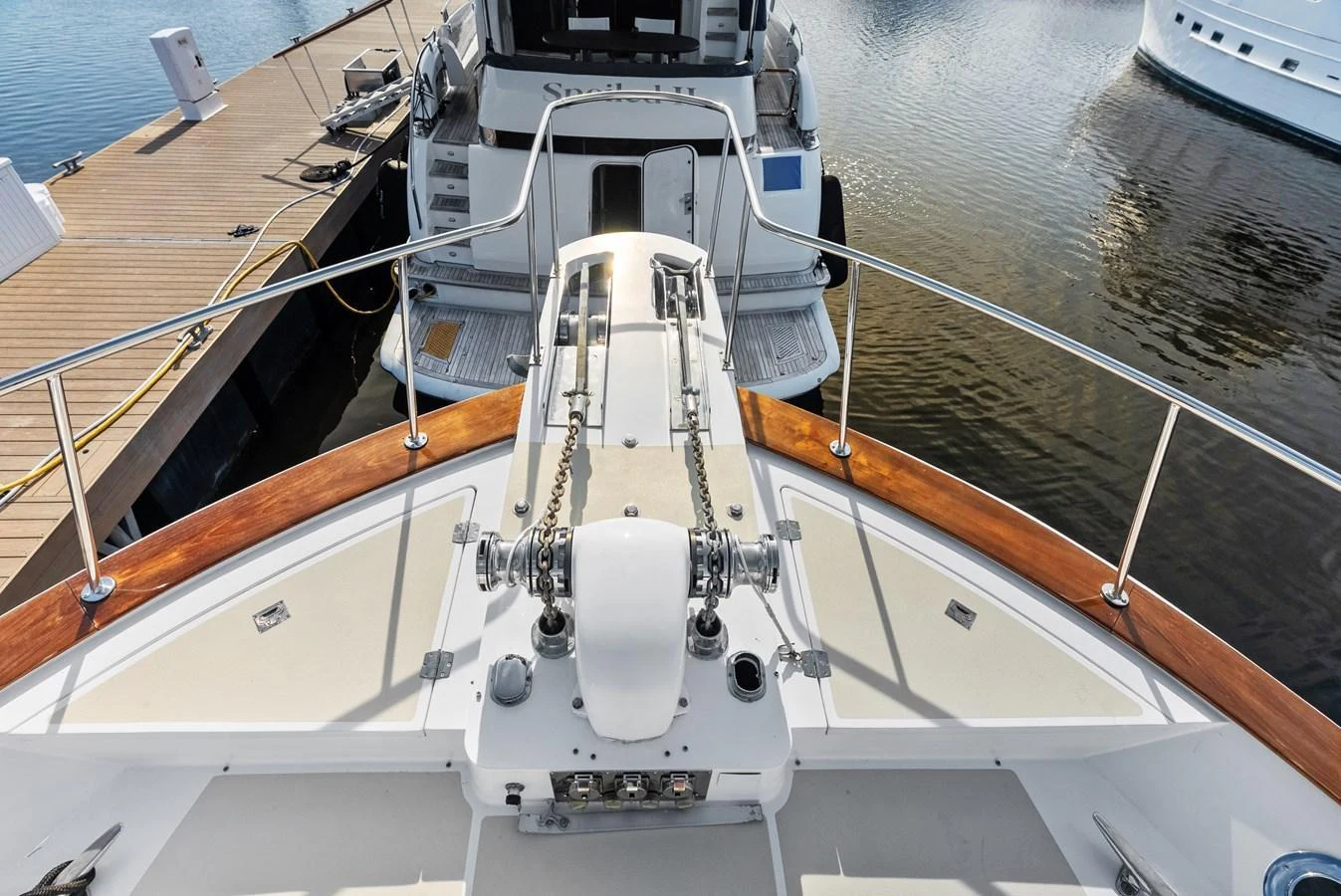 The image showcases the bow area of a yacht, featuring polished railings and anchor equipment. aboard EL LEGADO Yacht for Sale