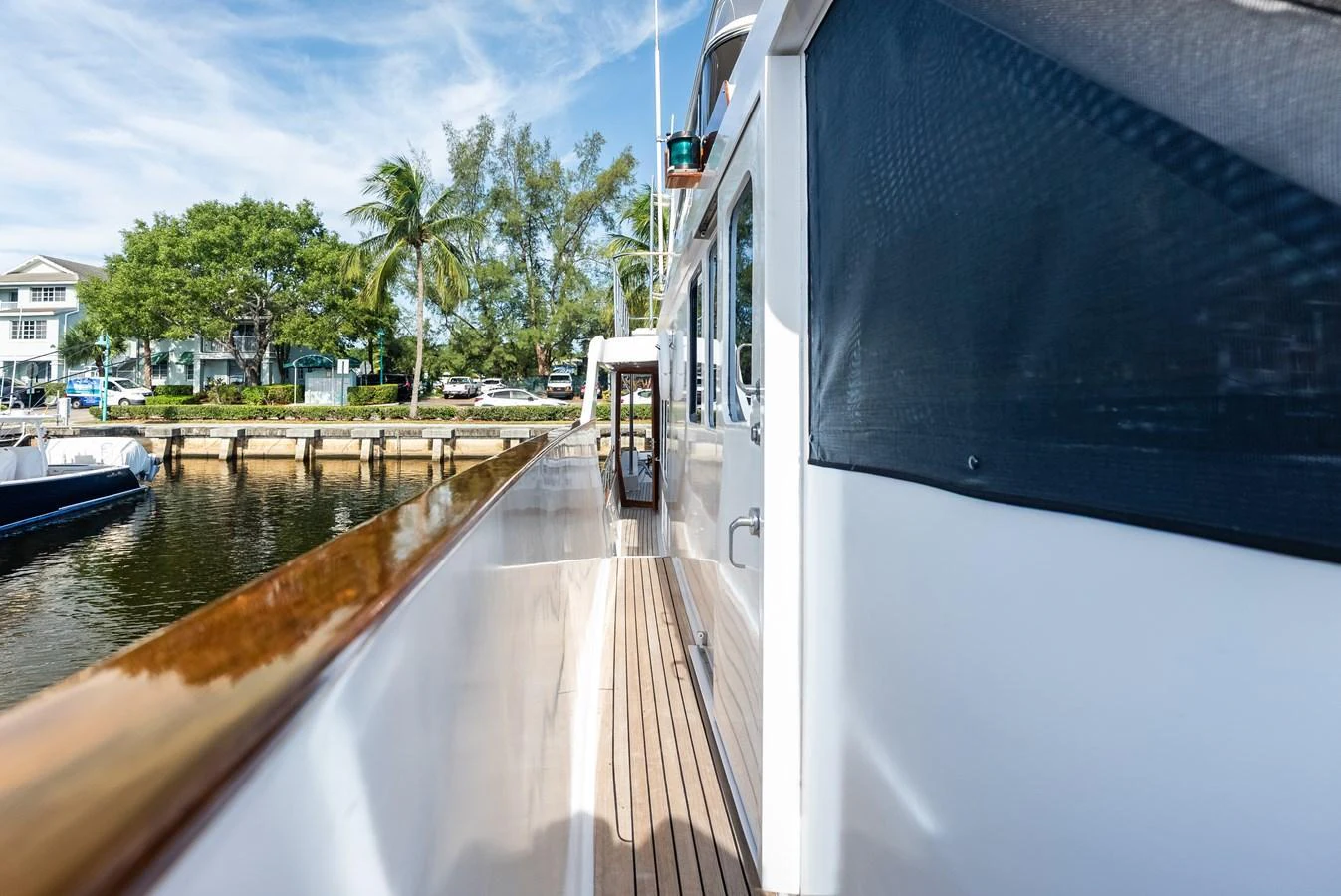 The yacht's side deck offers a sleek and inviting passageway with a view of the surrounding marina. aboard EL LEGADO Yacht for Sale