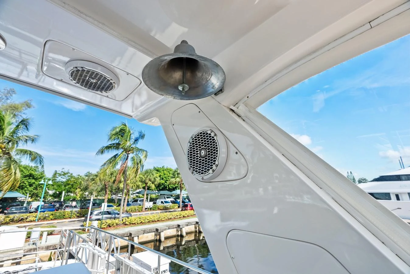 A close-up view of the yacht's exterior detailing, showcasing a speaker and a bell under a shaded area. aboard EL LEGADO Yacht for Sale