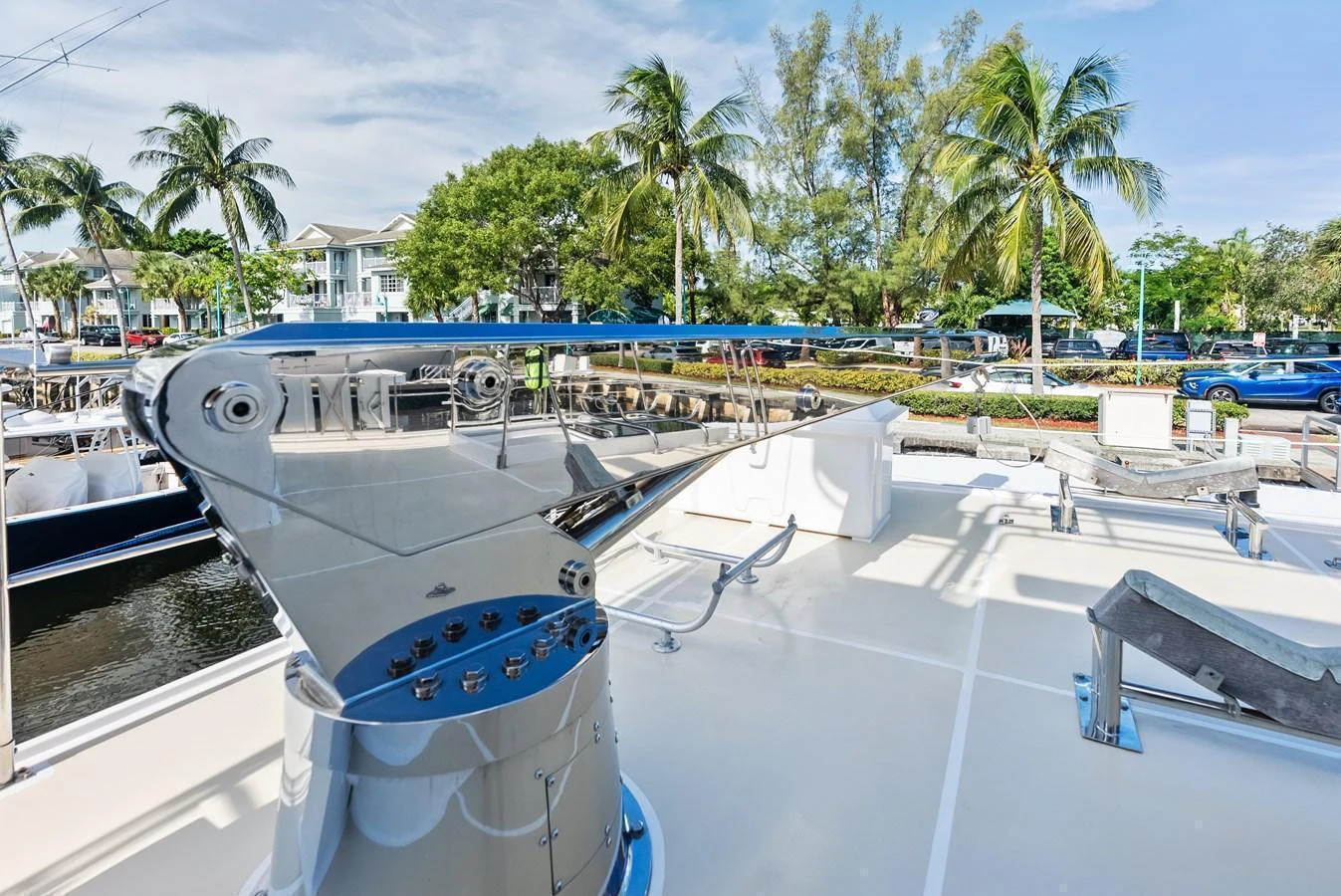 The image showcases a polished anchor windlass on the deck of the yacht, with a scenic marina in the background. aboard EL LEGADO Yacht for Sale