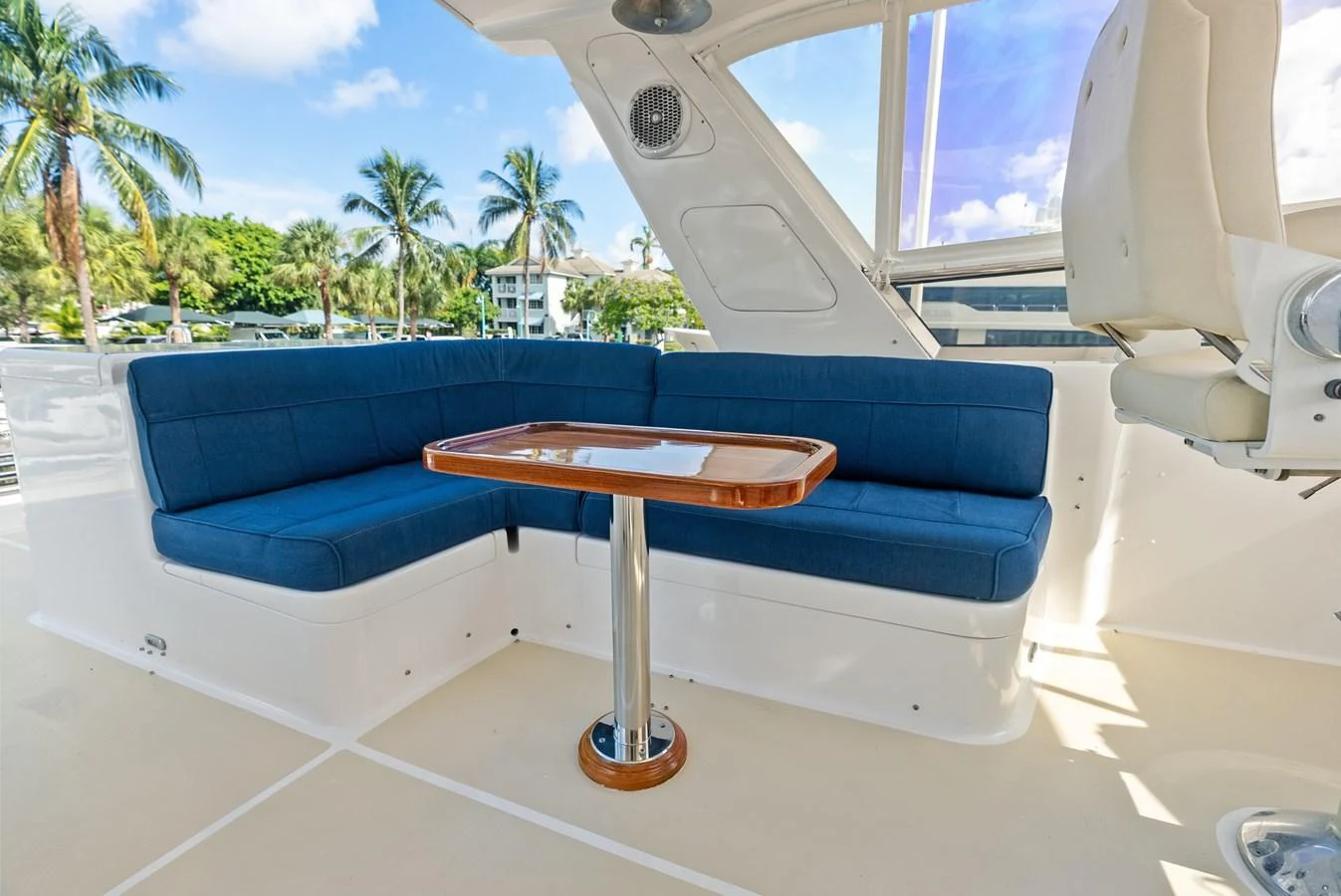 The flybridge features a comfortable seating area with a table, perfect for outdoor relaxation. aboard EL LEGADO Yacht for Sale