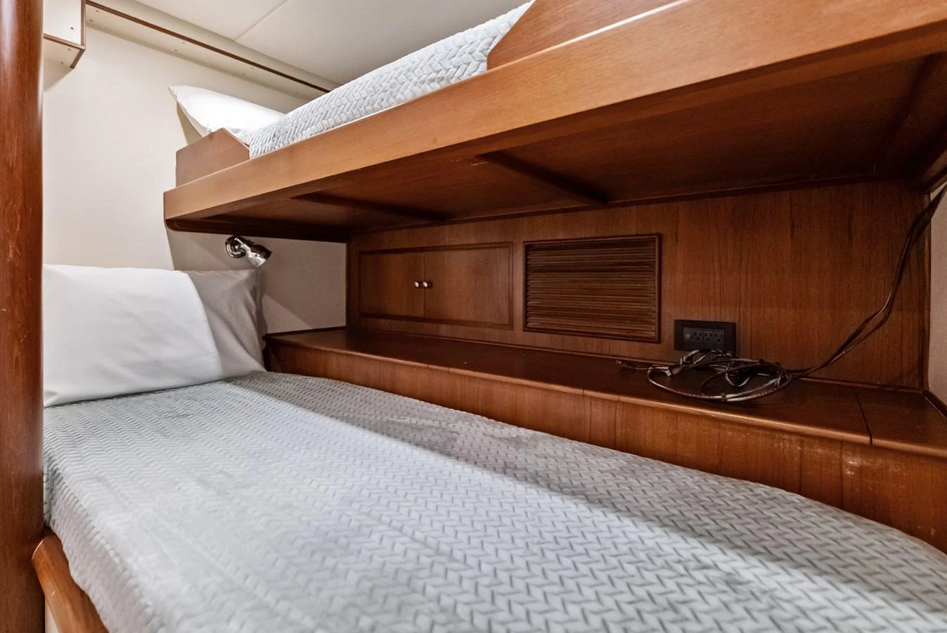 The cozy bunk cabin features comfortable bedding and wooden accents. aboard EL LEGADO Yacht for Sale
