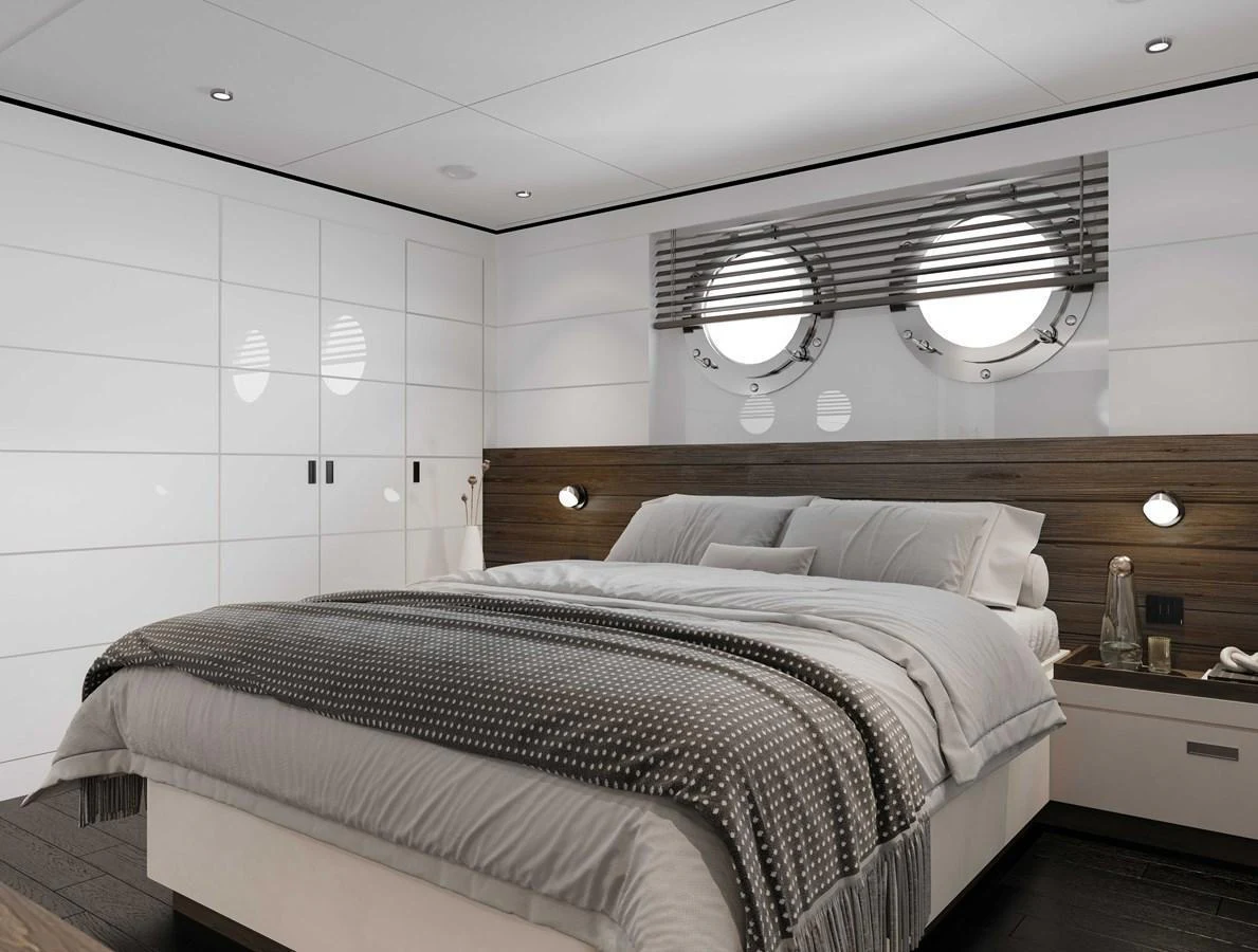 The stateroom features a luxurious bed with modern decor and porthole windows. aboard MAKO SHARK Yacht for Sale
