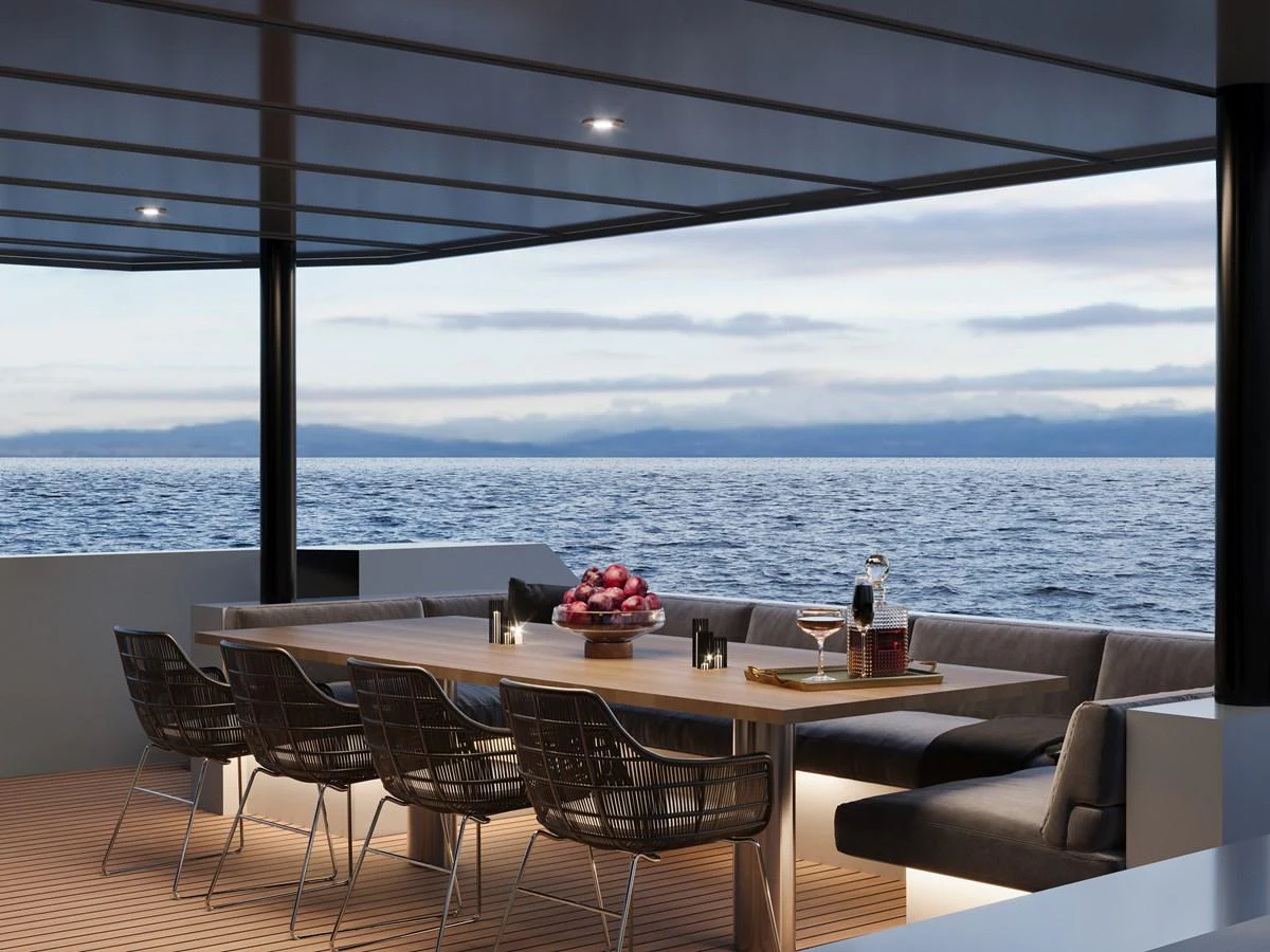 The aft deck features a stylish dining area with a stunning ocean view. aboard MAKO SHARK Yacht for Sale