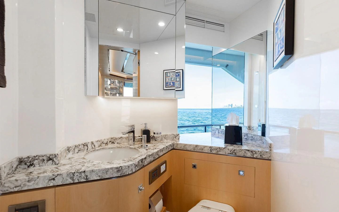 The yacht's bathroom features a sleek design with a marble countertop and a large mirror, offering a luxurious and modern feel. aboard WADDLE WE DO Yacht for Sale