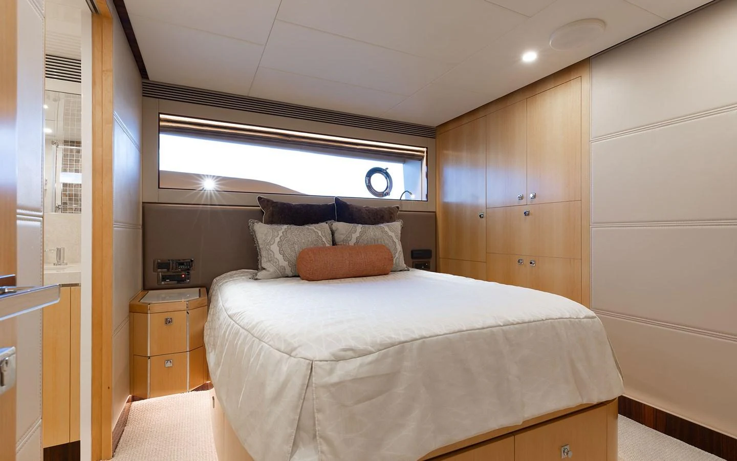 The stateroom features a cozy bed with elegant wooden cabinetry and soft lighting. aboard WADDLE WE DO Yacht for Sale